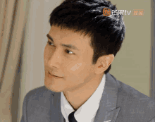 a close up of a man 's face with a chinese tv logo in the corner