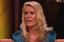 a blonde woman in a blue dress is making a face