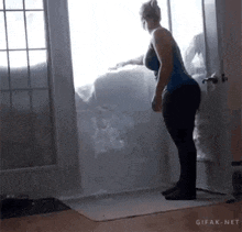 a woman is standing in front of a door holding a large piece of snow .