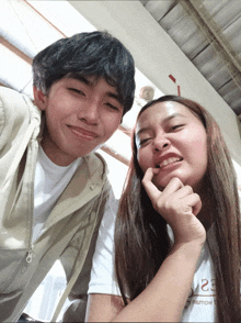 a boy and a girl are posing for a picture and the girl is wearing a white shirt that says 23 on it