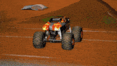 a monster jam advertisement is behind a monster truck on a dirt track