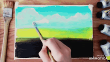 a person is painting a landscape on a canvas with the words made in animotica below