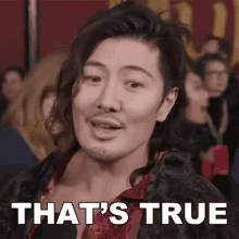 a man with a beard says that 's true in front of a crowd of people