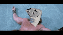 a man is swimming in a pool with a fish head