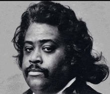 a black and white photo of a man with a mustache and long hair