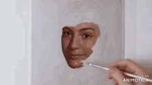 a person is painting a woman 's face and the words made in animatica are visible