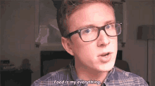 a man wearing glasses and a plaid shirt says food is my everything .