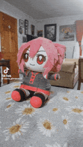 a stuffed animal with pink hair is sitting on a bed with a tiktok video