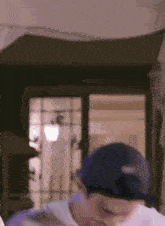a man wearing a baseball cap is standing in front of a door .