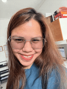 a woman wearing glasses is smiling for the camera