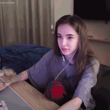 a woman wearing headphones sits at a desk with a purple screen behind her that says 151.50 / 5000 000 rub