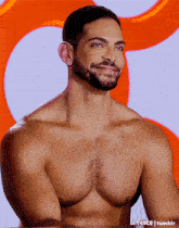 a shirtless man with a beard is smiling in front of an orange and white background