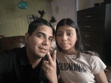 a man and a girl are posing for a picture and the girl is wearing a t-shirt that says oleana