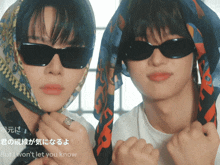 a man wearing sunglasses and a scarf around his head is next to another man wearing sunglasses and a scarf around his head