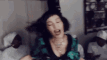 a woman in a green dress is making a funny face with her eyes closed .