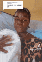 a woman wearing glasses holds a baby in her arms