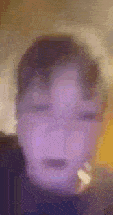 a blurry picture of a person 's face with a purple background