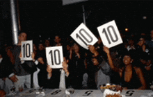 a crowd of people holding up signs that say 10