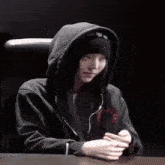 a person wearing a black hoodie and a black beanie