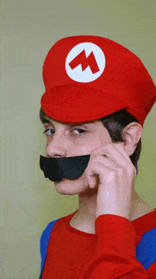 a boy in a mario costume has a fake mustache on his face