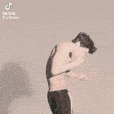 a tiktok video of a shirtless man with a tattoo on his chest