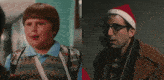 a man wearing glasses and a santa hat is next to a boy with a bandage on his arm