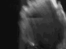 a black and white photo of a person 's face with smoke coming out of their mouth
