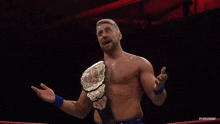 a man in a wrestling ring with a belt around his waist