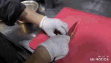 a person wearing white gloves is cutting vegetables on a red cutting board made in animotica