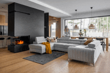 a woman is standing in a living room with a large sectional couch
