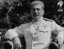 a man in a white uniform is sitting in a chair with a pathe logo in the corner