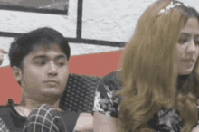a man and a woman are sitting next to each other on a couch