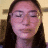 a close up of a woman wearing glasses and making a face .