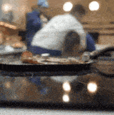a pan of food sits on a stove top with a blurry background