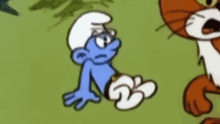 a cartoon smurf with glasses is laying on the ground next to a cat .