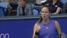 a woman in a purple tank top with an adidas logo on the front