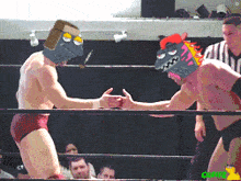 two men are wrestling in a ring with one wearing a mask that looks like a dinosaur