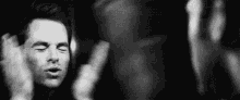 a black and white photo of a man with his hands in the air .