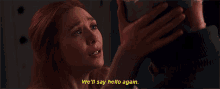 a woman with red hair is smiling while holding a person 's hand and says " we 'll say hello again "
