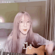 a girl with pink hair and glasses is playing a guitar with chinese writing on it