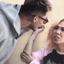 a man kissing a woman 's hand while wearing sunglasses