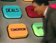 a man in a suit and tie is looking at buttons that say deals and tomorrow