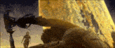 a man is laying on the ground in front of a giant yellow object