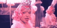 a woman with pink hair wearing a tiara