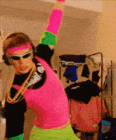 a man in a neon outfit is dancing in front of a big up sign