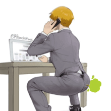 a man in a suit is sitting at a desk with a laptop and talking on a phone