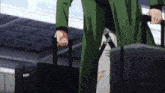 a man in a green coat is carrying a black suitcase