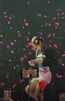 a woman in a black shirt that says blackpink is holding a cell phone
