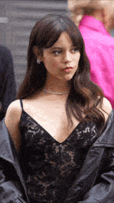 a woman wearing a black lace top and a leather jacket