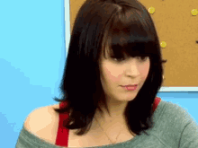 a woman is standing in front of a pinboard with smiley faces on it
